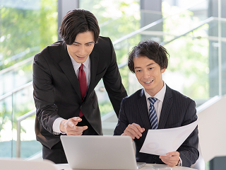 男性2人がPCを見ながら打ちあわせをしている様子 イメージ写真